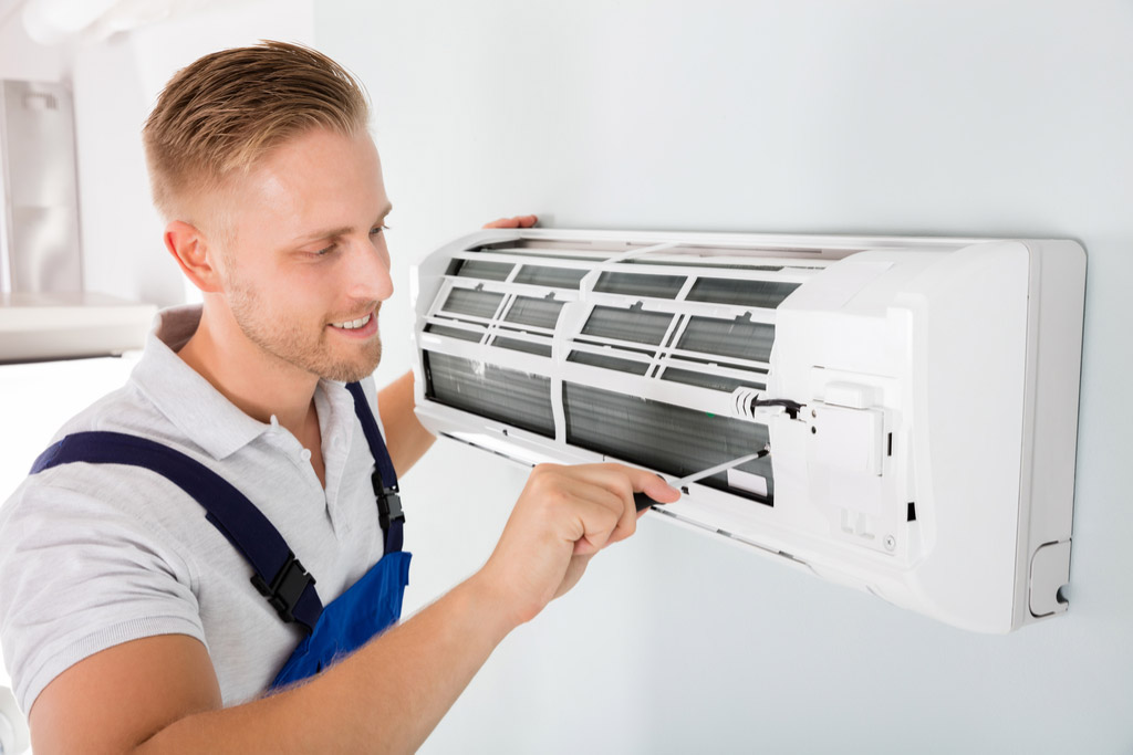 HVAC technician maintaining a ductless air conditioner in Redwood City
