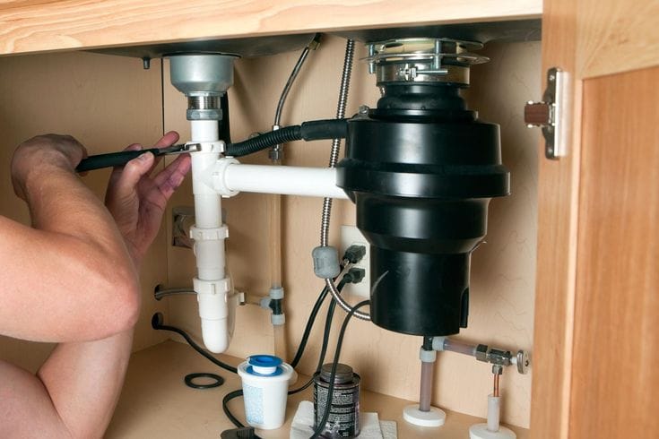 Plumber repairing a garbage disposal in Redwood City