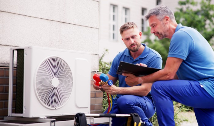 HVAC technicians installing an outdoor air conditioning unit in Redwood City